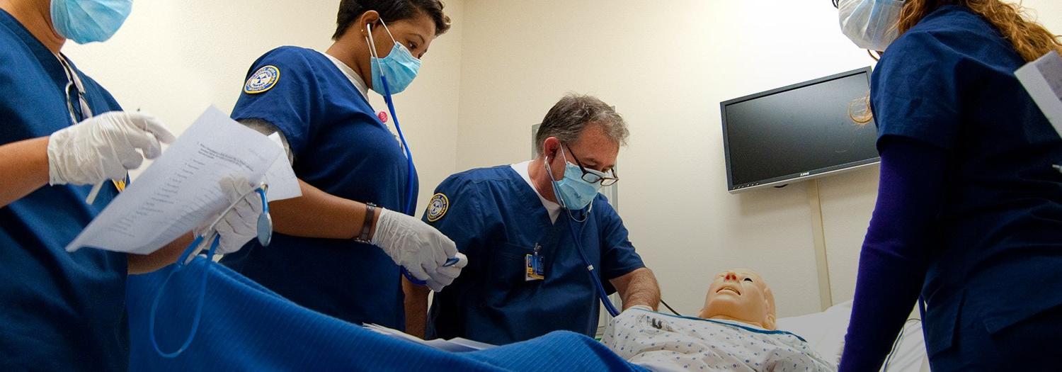 Students around a lab dummy in the classroom.